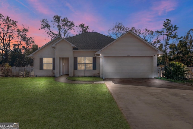 ranch-style house with a garage and a yard