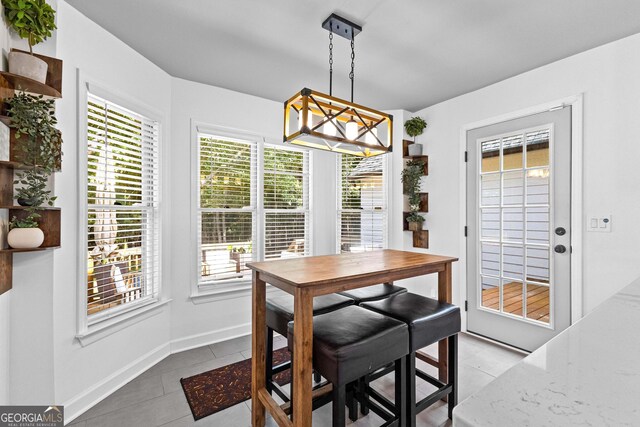 kitchen featuring white cabinetry, tile patterned flooring, butcher block counters, stainless steel appliances, and decorative light fixtures