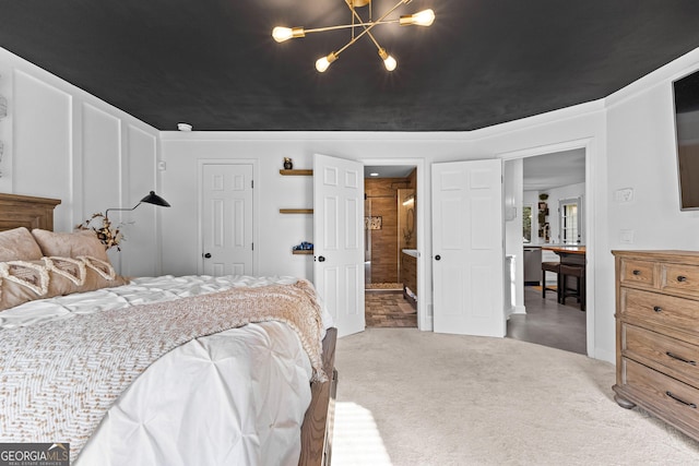 bedroom featuring ensuite bathroom, carpet floors, and an inviting chandelier