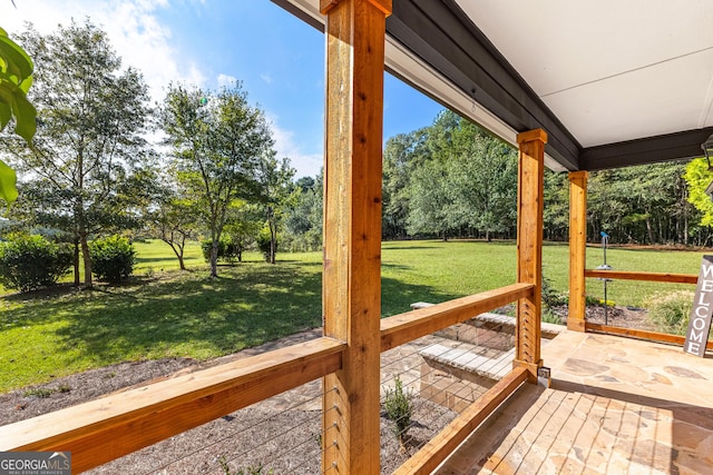 wooden terrace featuring a yard and a patio area