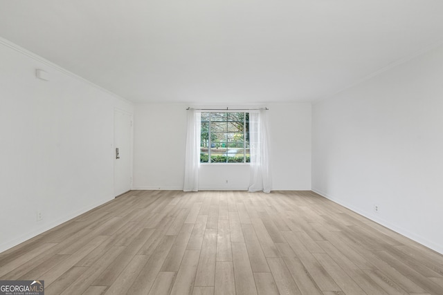 empty room featuring light hardwood / wood-style flooring and ornamental molding