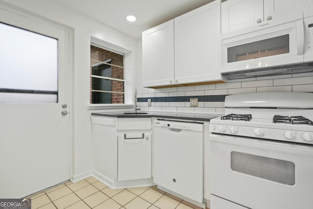 kitchen with light tile patterned flooring, sink, white cabinetry, white appliances, and decorative backsplash