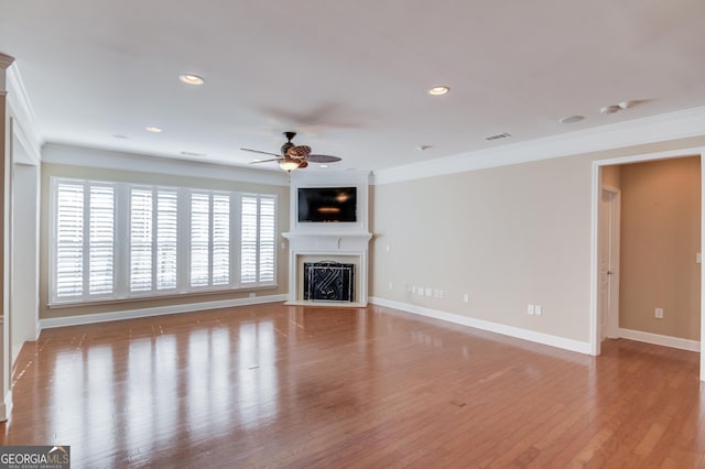 6706 Amherst Dr, Hoschton, GA 30548 - unfurnished living room featuring ornamental molding, ceiling fan, a fireplace, wood finished floors, and recessed lighting
