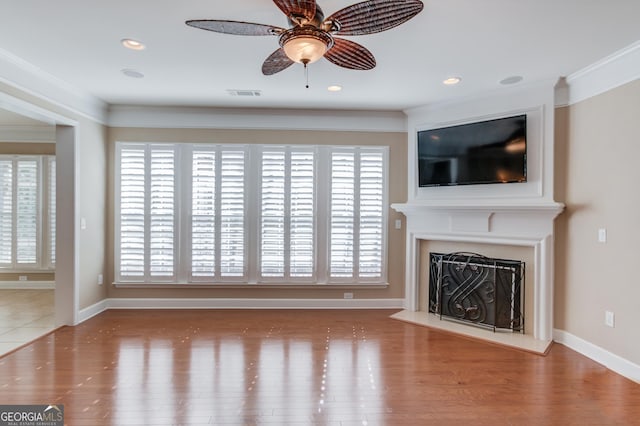 6706 Amherst Dr, Hoschton, GA 30548 - unfurnished living room featuring ornamental molding, a fireplace with raised hearth, wood finished floors, a ceiling fan, and recessed lighting