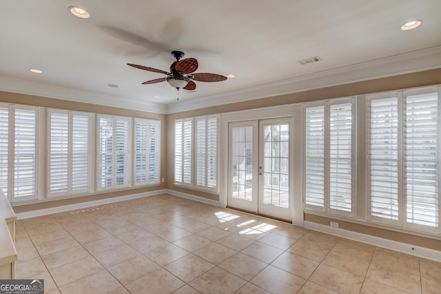 empty room featuring ornamental molding, a wealth of natural light, and french doors