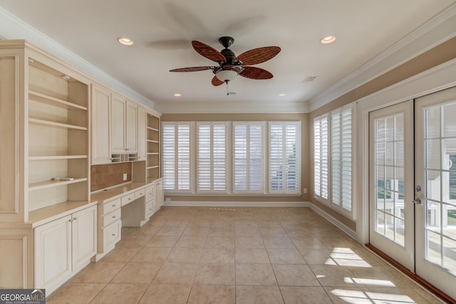 unfurnished office with built in desk, light tile patterned floors, ceiling fan, crown molding, and french doors