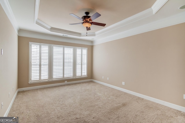 carpeted empty room featuring crown molding, ceiling fan, and a tray ceiling