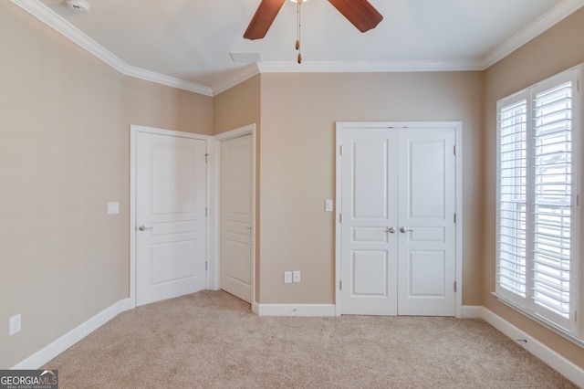 unfurnished bedroom featuring ornamental molding, light carpet, and multiple windows