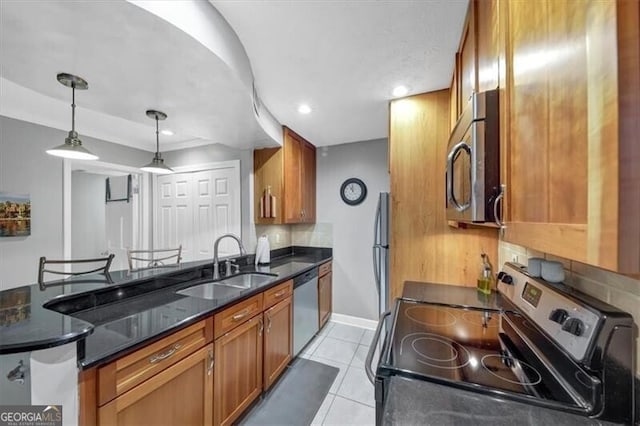 kitchen featuring sink, light tile patterned floors, appliances with stainless steel finishes, backsplash, and decorative light fixtures