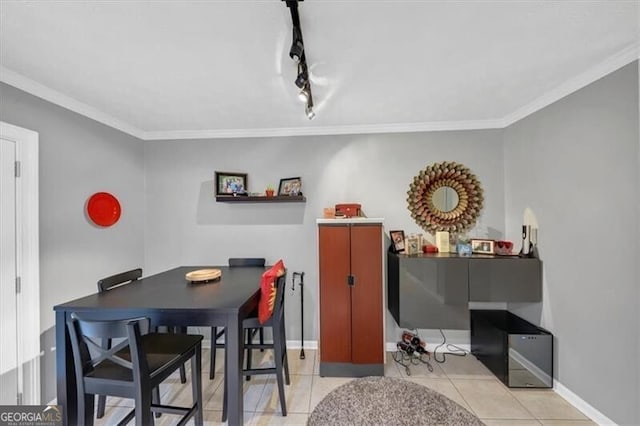 dining area featuring light tile patterned floors, track lighting, and ornamental molding