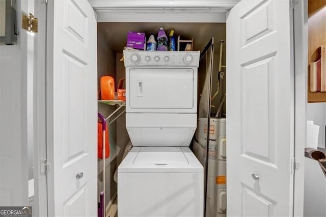 washroom featuring stacked washer / dryer and electric water heater