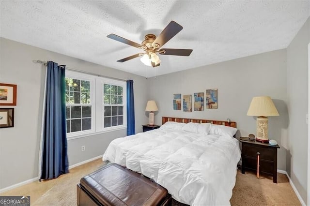 carpeted bedroom with ceiling fan and a textured ceiling