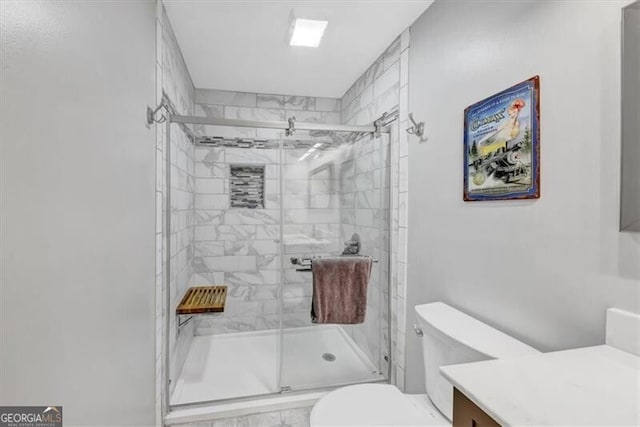 bathroom featuring vanity, toilet, and an enclosed shower