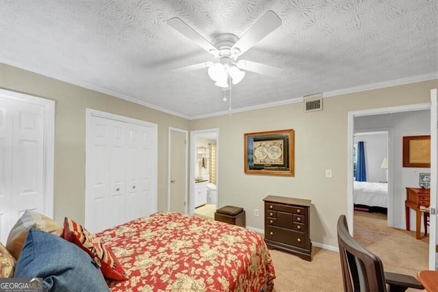 carpeted bedroom with crown molding, ensuite bath, a textured ceiling, two closets, and ceiling fan