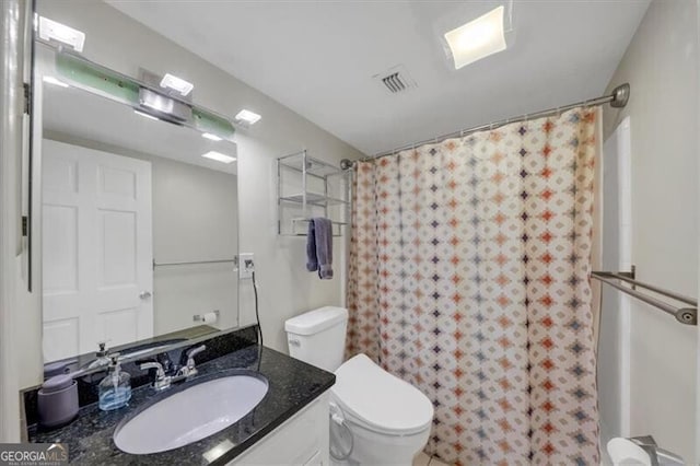 bathroom with vanity, curtained shower, and toilet