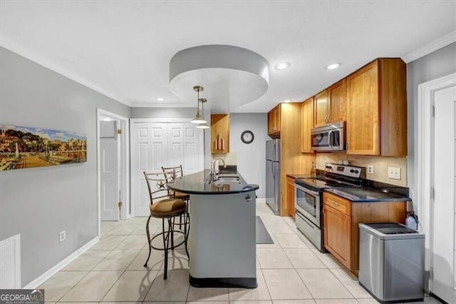 kitchen with sink, a breakfast bar area, light tile patterned floors, pendant lighting, and stainless steel appliances