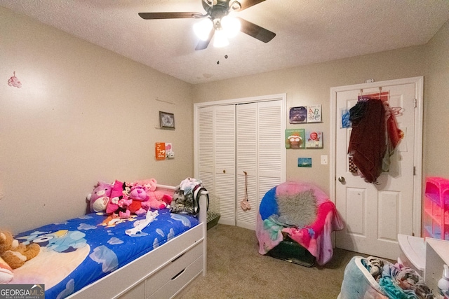 carpeted bedroom with a textured ceiling, ceiling fan, and a closet