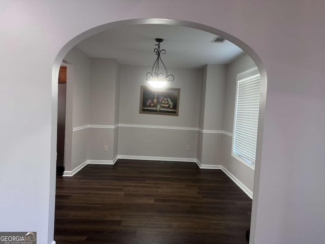 unfurnished dining area featuring dark wood-type flooring