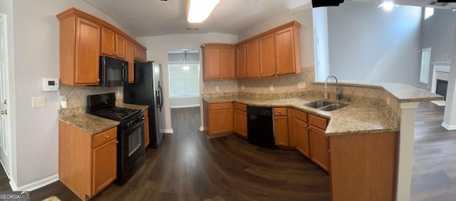 kitchen featuring black appliances, sink, dark hardwood / wood-style flooring, kitchen peninsula, and light stone countertops