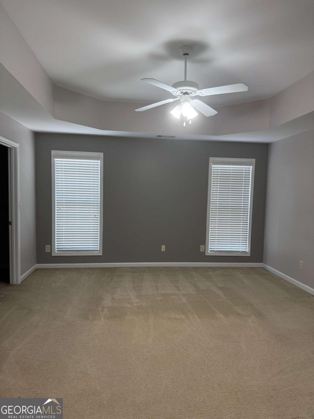 carpeted spare room featuring ceiling fan