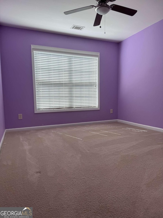 carpeted spare room with ceiling fan