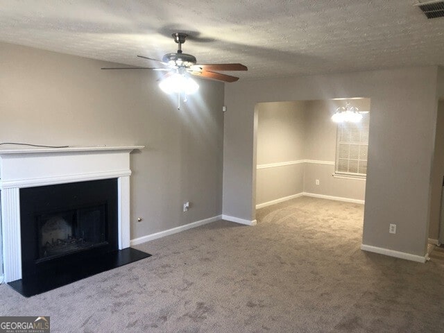 unfurnished living room with carpet flooring, ceiling fan with notable chandelier, and a textured ceiling