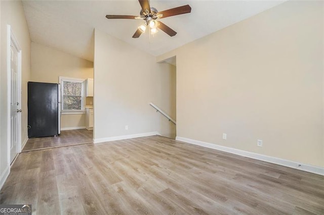 empty room featuring ceiling fan, lofted ceiling, and light hardwood / wood-style floors