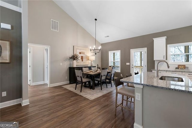 dining space with baseboards, dark wood-style flooring, visible vents, and a healthy amount of sunlight