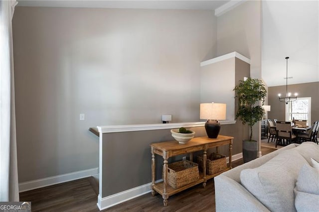 living room with dark wood-style floors, high vaulted ceiling, an inviting chandelier, and baseboards