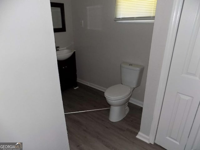 bathroom with hardwood / wood-style flooring, vanity, and toilet