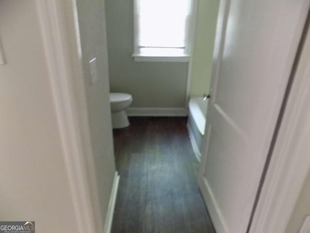 bathroom with wood-type flooring and toilet