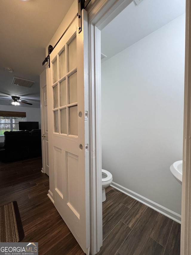 bathroom with hardwood / wood-style floors, toilet, and ceiling fan