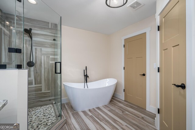 122 Acadia Dr Unit 110, Ellijay, GA 30540 - bathroom featuring wood finish floors, baseboards, a shower stall, visible vents, and a freestanding bath