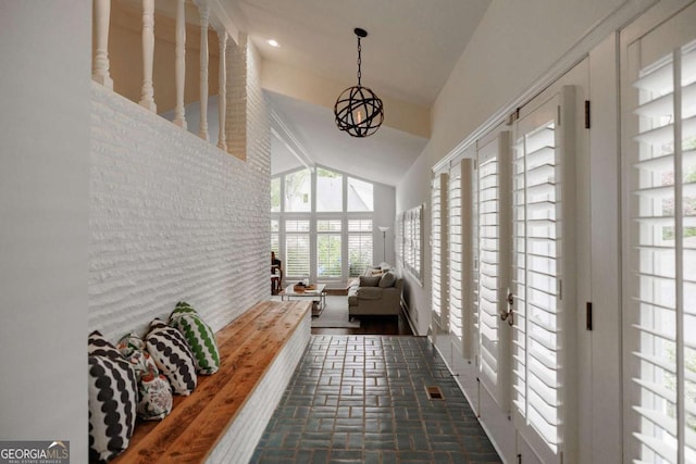 sunroom with lofted ceiling and a chandelier