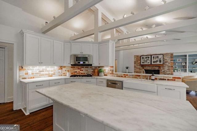 kitchen featuring white cabinetry, sink, stainless steel appliances, and kitchen peninsula