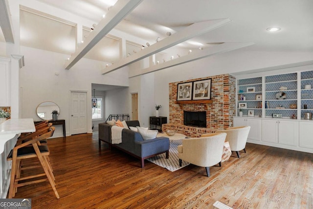 living room with lofted ceiling, hardwood / wood-style floors, and a brick fireplace