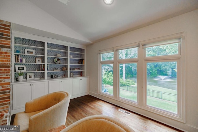 unfurnished room with lofted ceiling and light wood-type flooring