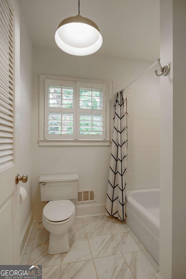 bathroom featuring shower / bath combo and toilet