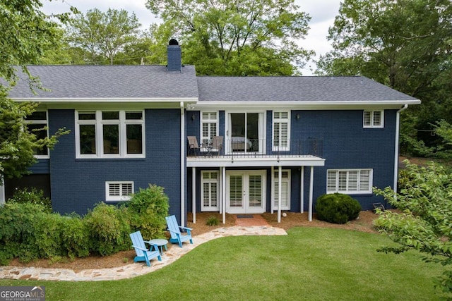 rear view of property featuring a wooden deck and a lawn