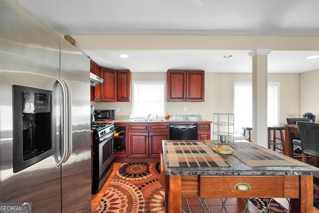 kitchen featuring sink, black appliances, and ornate columns