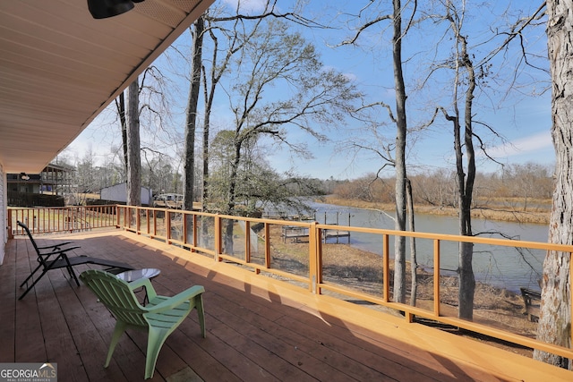 wooden deck featuring ceiling fan and a water view