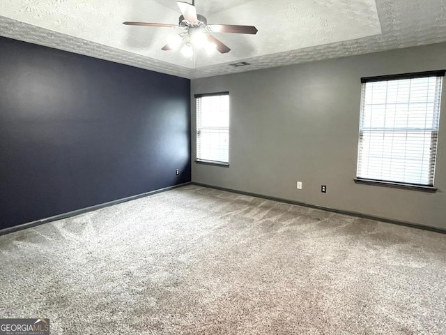 carpeted empty room featuring ceiling fan and a textured ceiling