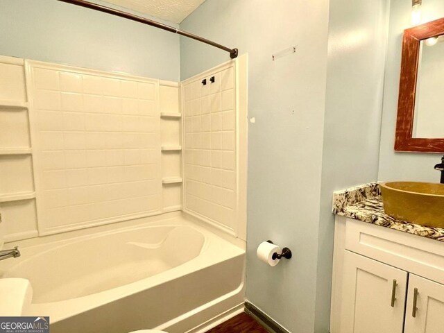 bathroom featuring vanity, a textured ceiling, and washtub / shower combination