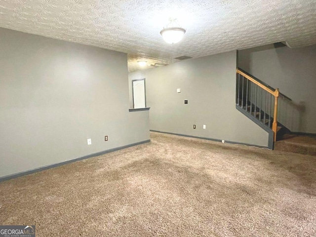 carpeted empty room featuring a textured ceiling