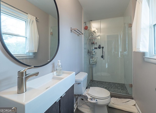 bathroom featuring vanity, toilet, and a shower with door