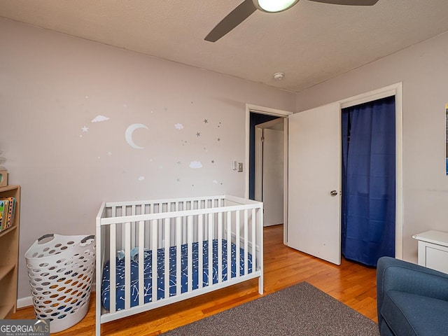 bedroom featuring wood-type flooring, ceiling fan, and a closet