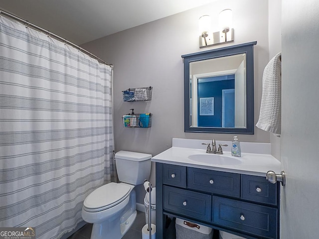 bathroom with tile patterned flooring, vanity, and toilet