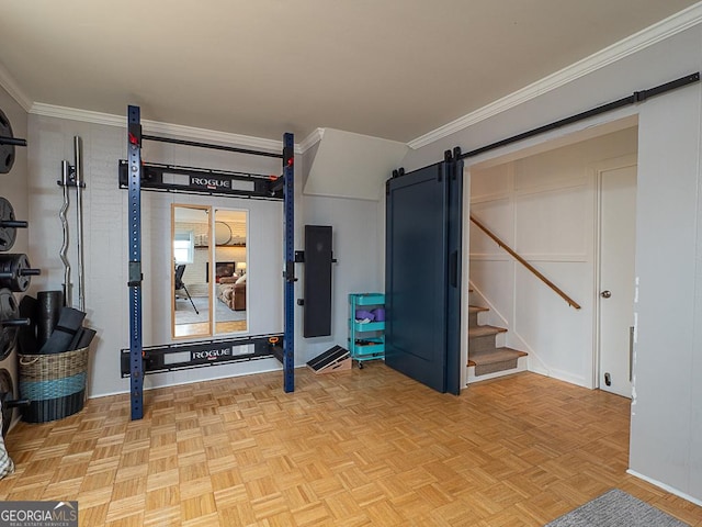 workout room featuring ornamental molding, a barn door, and light parquet floors