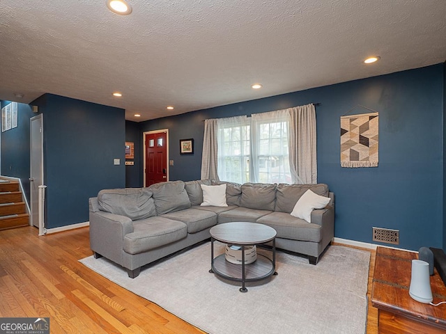 living room featuring light hardwood / wood-style floors and a textured ceiling