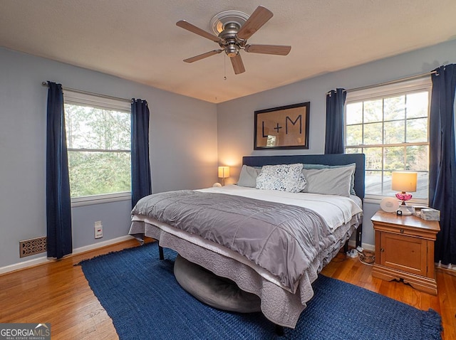 bedroom with ceiling fan, lofted ceiling, and light wood-type flooring